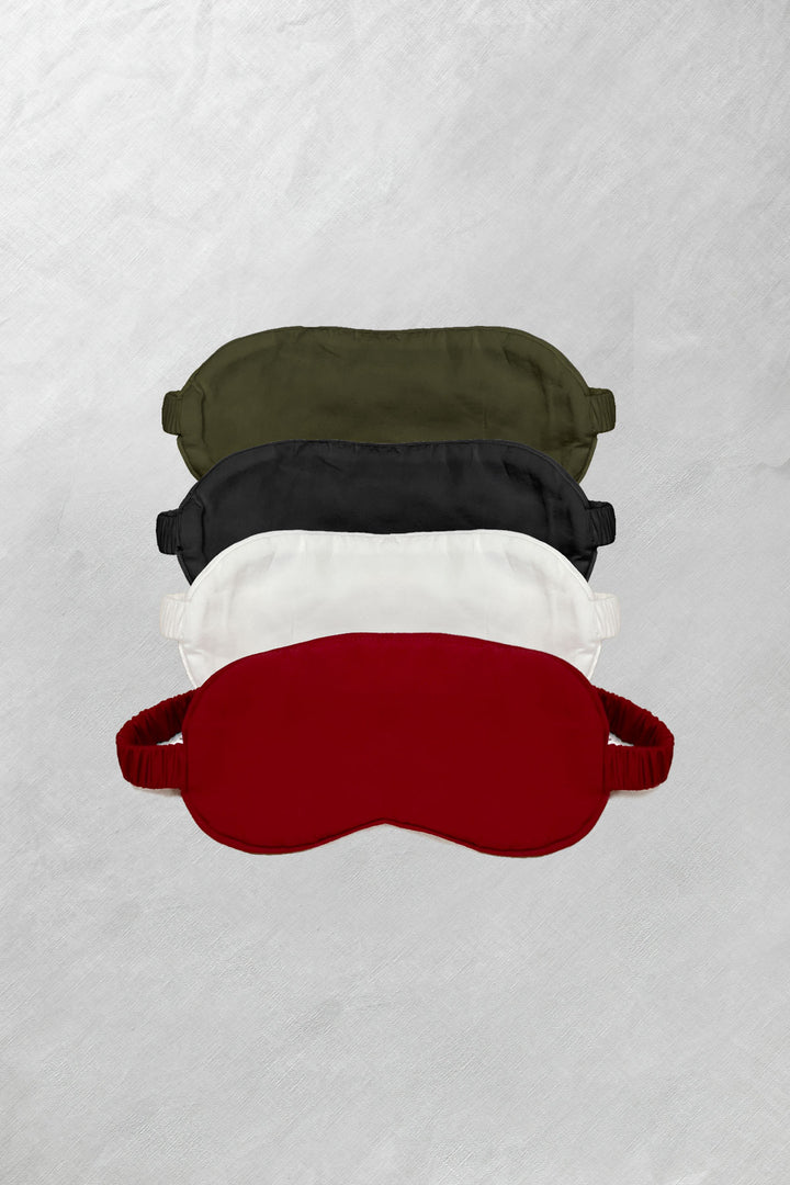 Bamboo sleep masks in olive, black, and red laid out flat on a white background