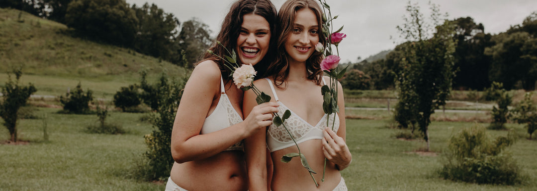women in field holding flowers in eco lingerie