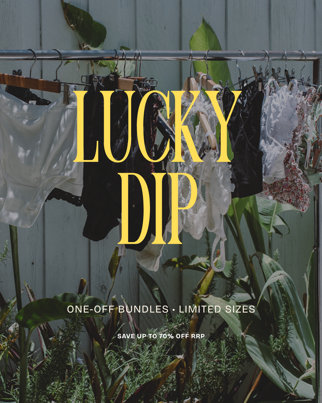 Clothing on a rack with 'Lucky Dip' text overlay, surrounded by plants.
