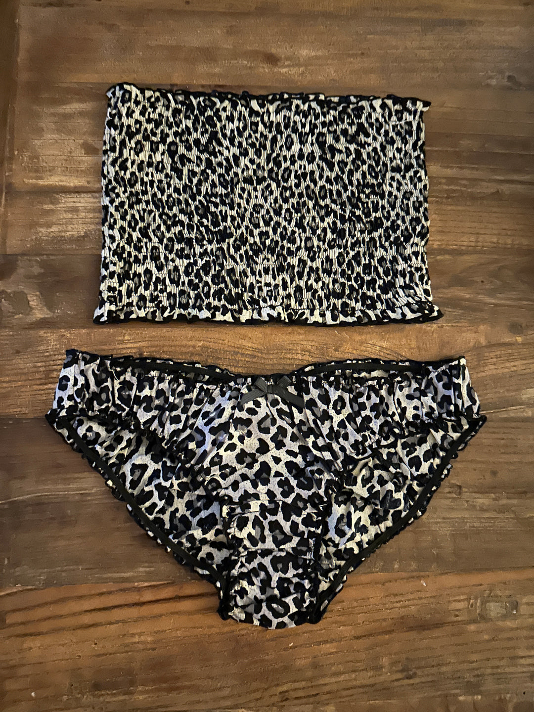Flatlay of cotton bandeau and underwear in leopard print on wood