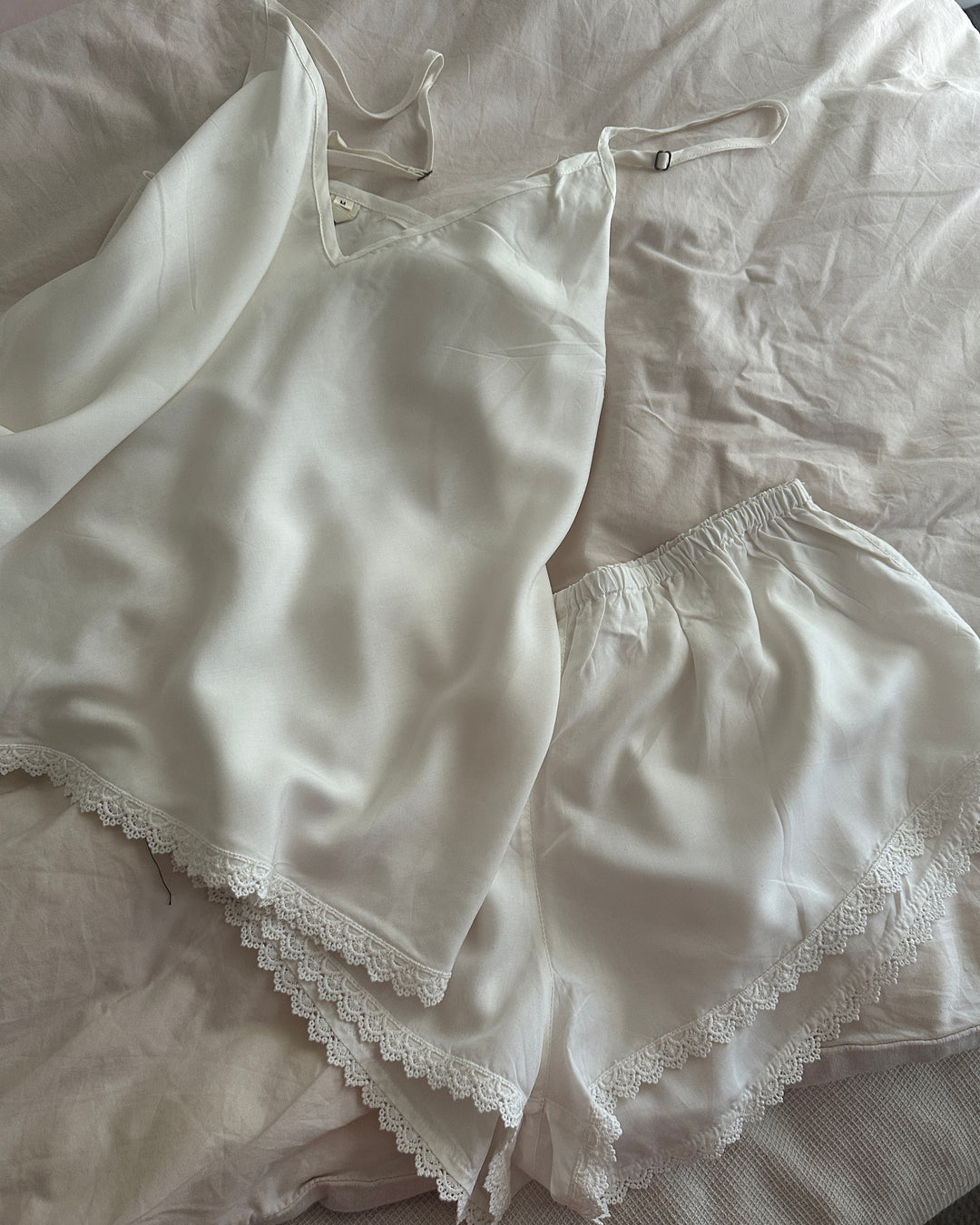 White lace-trimmed lingerie set on a light-colored fabric background