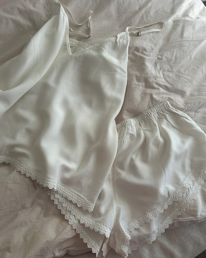 White lace-trimmed lingerie set on a light-colored fabric background