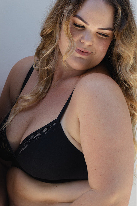 woman wearing black lingerie against a white background