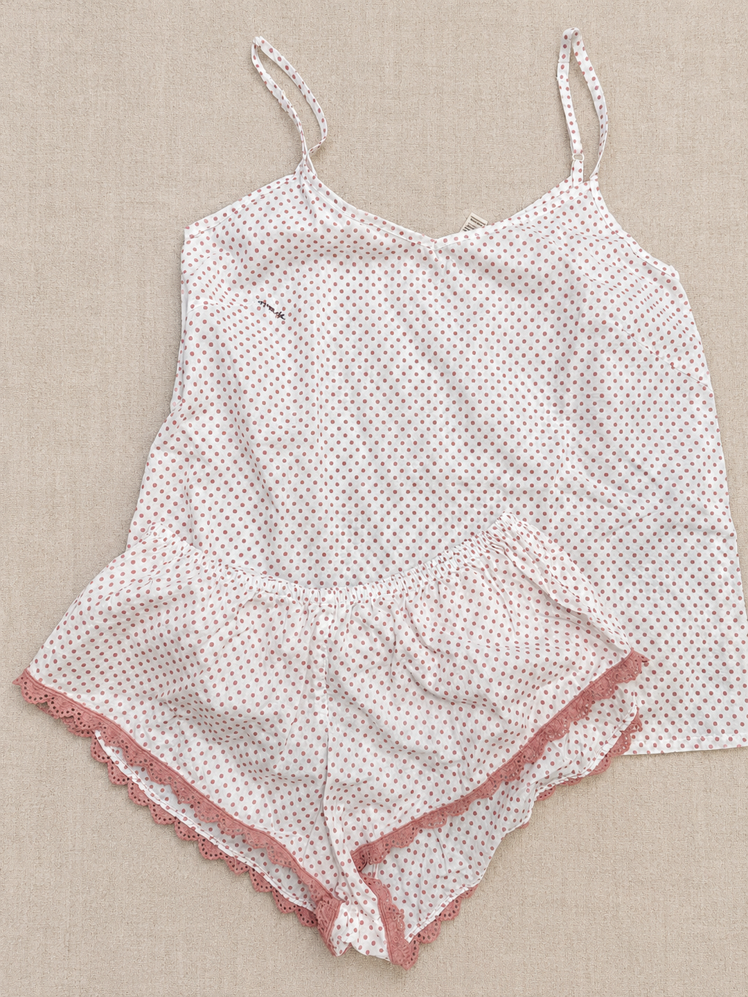 White lace nightgown with pink trim on a beige background