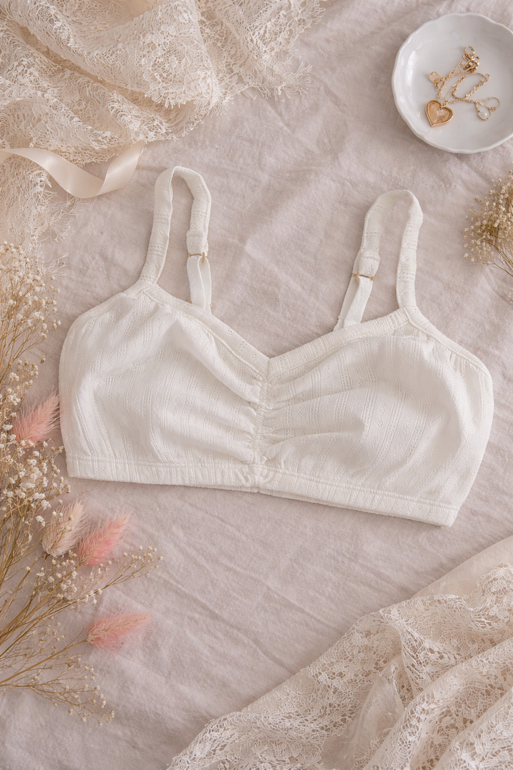 White organic cotton bralette on a textured surface with decorative elements