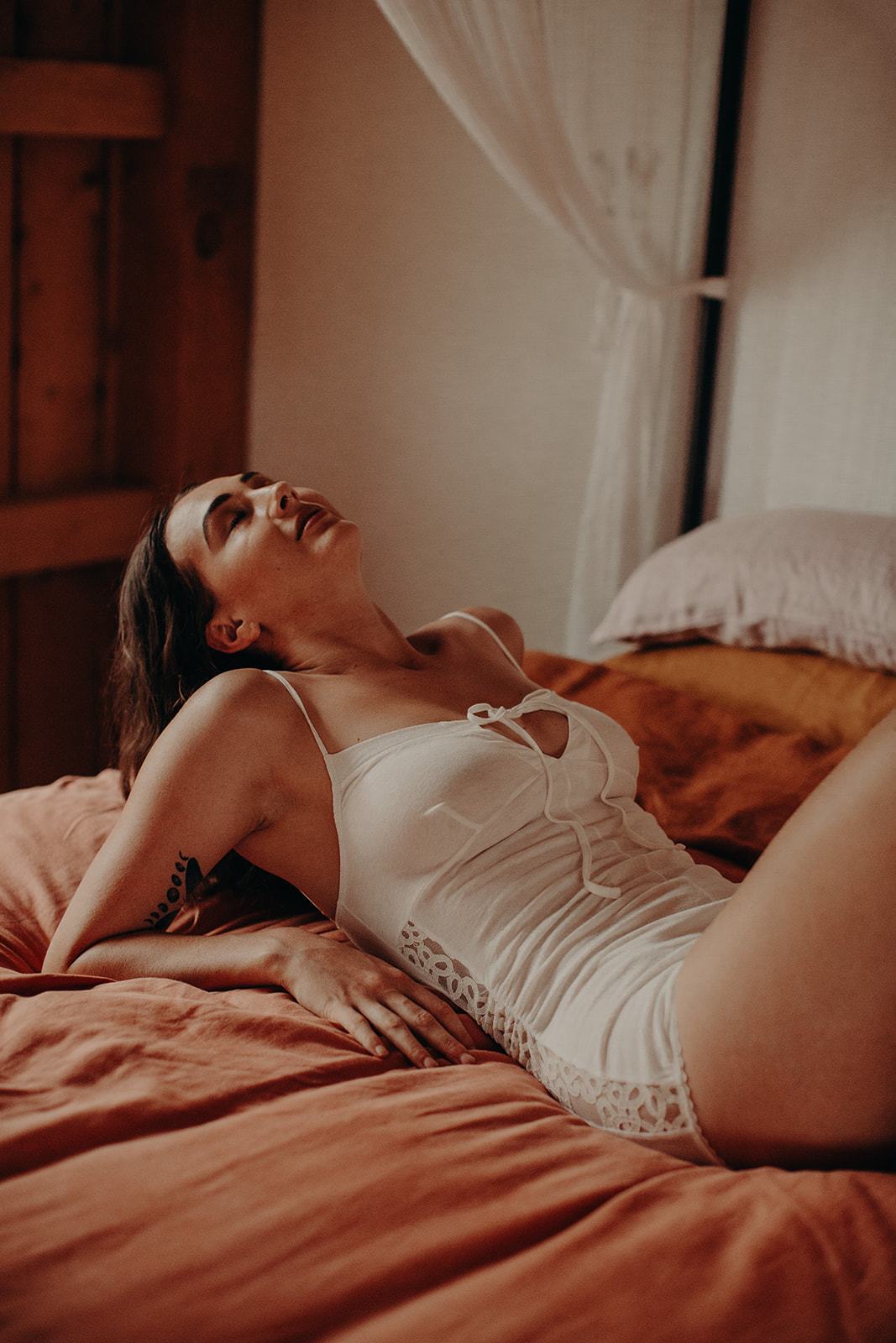 model lying back wearing organic cotton romper playsuit