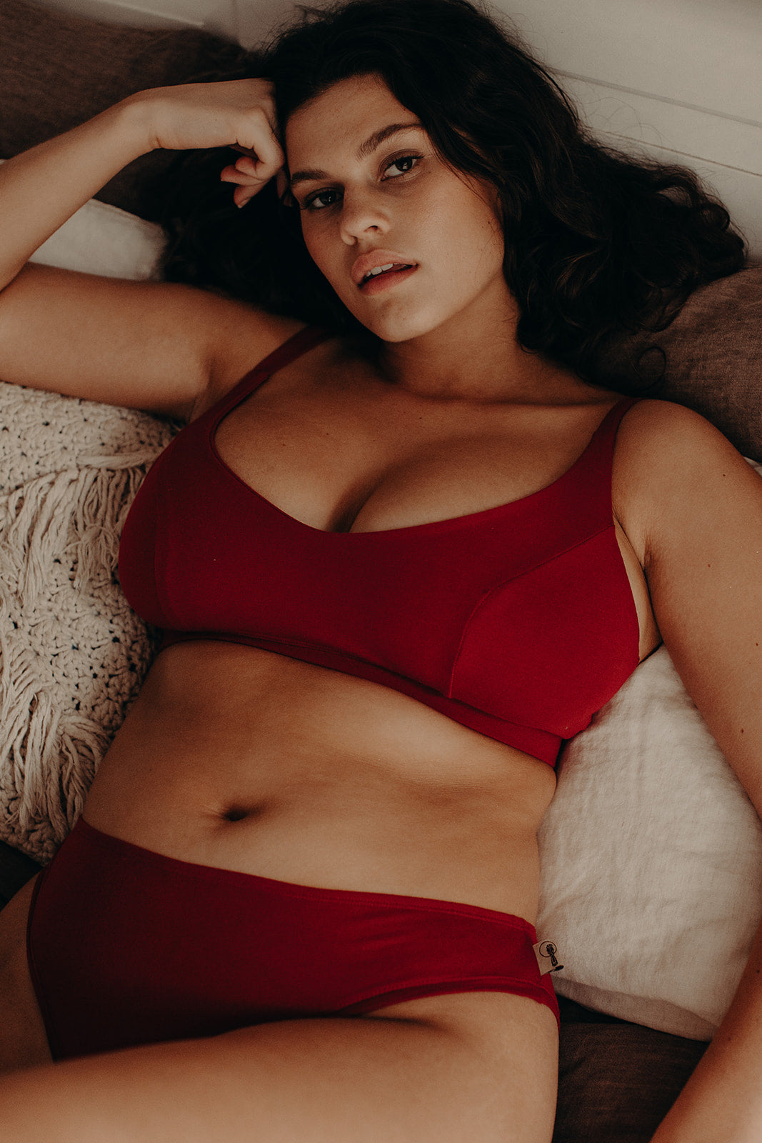 Model with large bust wearing organic cotton crop bra in red