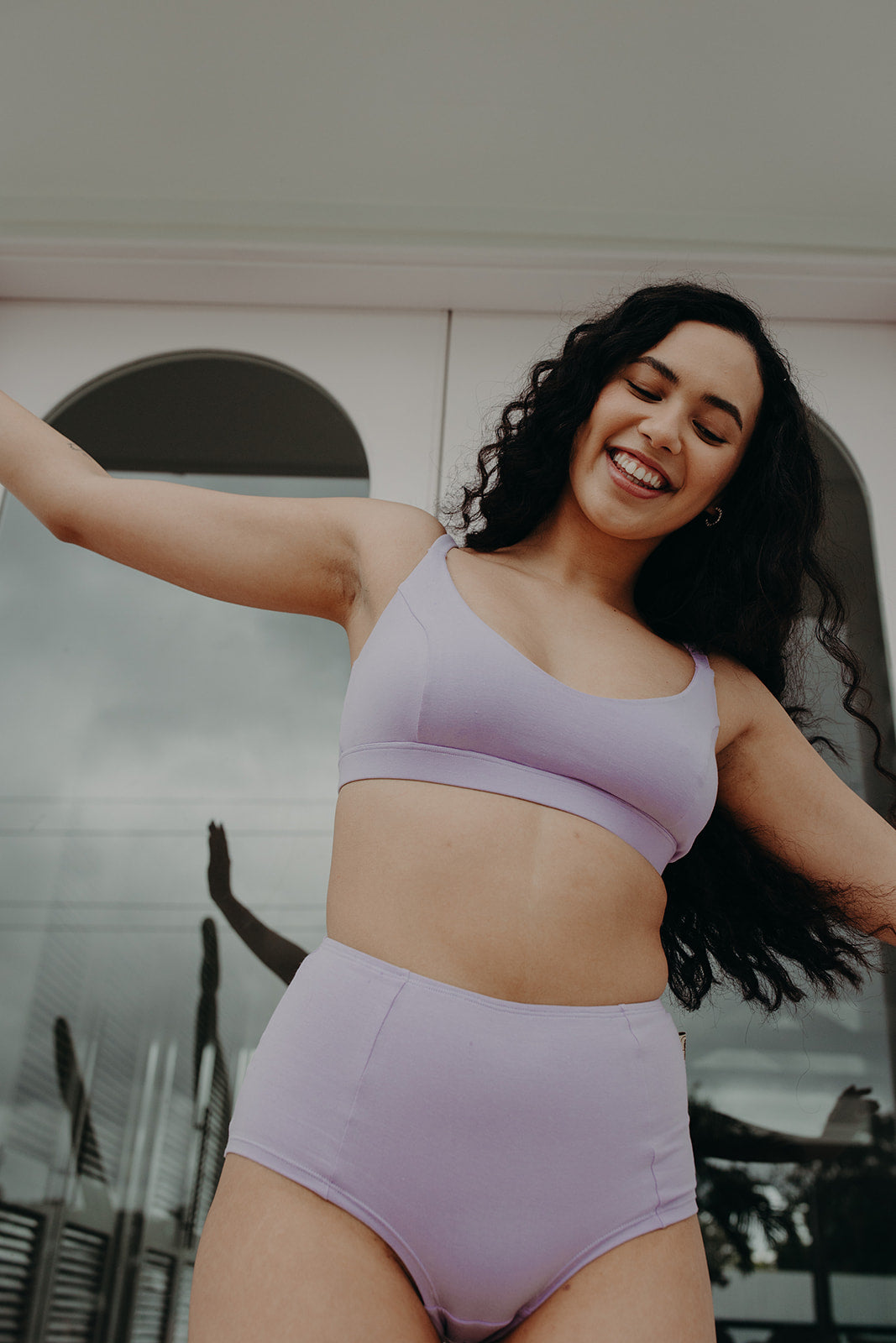 woman dances and smiles in lavender underwear