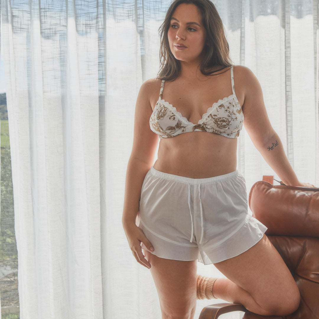 model wearing shorts in organic cotton in white with bralette in floral print