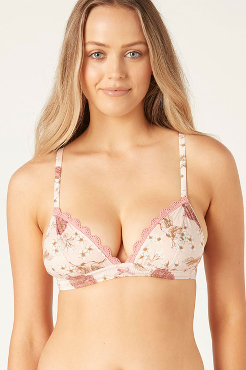 A woman wearing a beige and pink floral bralette with dusty rose scalloped lace trim.