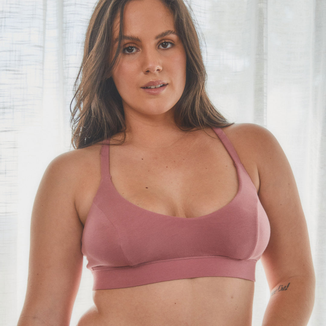 model with dd bust showing front view of bralette in pink