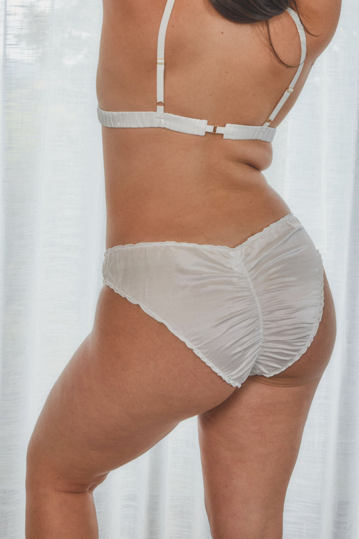 model showing back view of frilly silk underwear